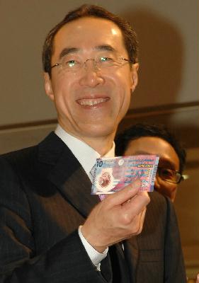 唐英年展示新拾元塑質鈔票。