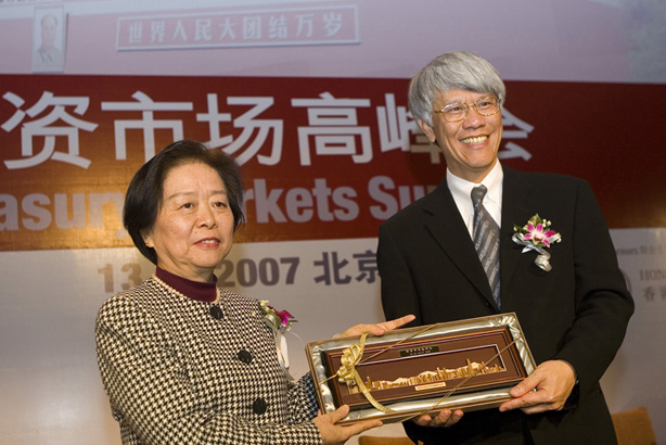 金融管理局总裁任志刚在财资市场高峰会上致送纪念品给中国人民银行副行长吴晓灵。