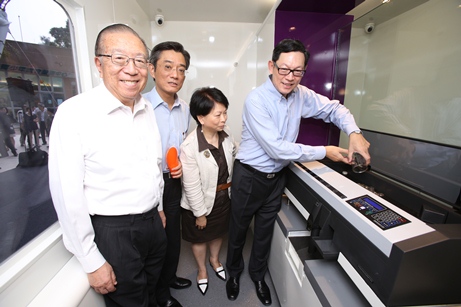 Mr Norman Chan, Chief Executive of the HKMA, Ms Lydia Chan, Head(Currency) of the HKMA, Mr Stanley Ying, Permanent Secretary for Transport & Housing (Housing) cum Director of Housing, and Mr Charles Lee, Vice Patron, Community Chest, (from right to left) demonstrate the functions of the coin counting machine in the Coin Cart.