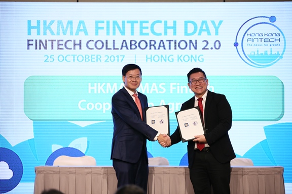 Mr Shu-pui Li, Executive Director of the HKMA (left) and Mr Roy Teo, Head, Financial Centre Development Department of MAS (right) exchange the Co-operation Agreement, which was signed between heads of the two organisations, at the HKMA Fintech Day today.