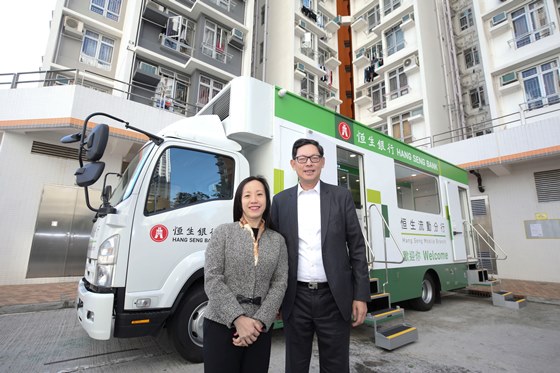 Ms. Louisa Cheang (left), Vice-Chairman and Chief Executive of Hang Seng Bank, and Mr. Norman Chan (right), Chief Executive of the HKMA, take a photo together in front of the mobile branch.