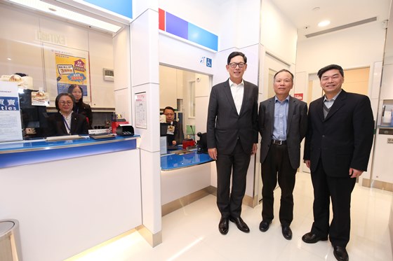 Mr. Chen Xiaozhou (second from right), Chairman of Nanyang Commercial Bank, Mr. Fang Hongguang (first from right), Vice Chairman and Chief Executive of Nanyang Commercial Bank, and Mr. Norman Chan (third from right), Chief Executive of the HKMA, take a photo together in front of the bank counter which facilitates access by people who are physically challenged.