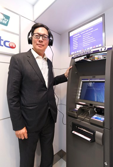 Mr. Norman Chan, Chief Executive of the HKMA, tries out the voice navigation ATM.