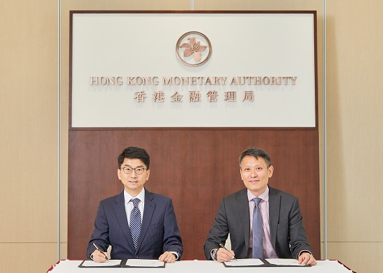 Mr Nelson Chow, Chief Fintech Officer of the HKMA (left), and Mr Richard Teng, Chief Executive Officer of the FSRA, sign and exchange the Co-operation Agreement in Hong Kong today (26 June 2018).