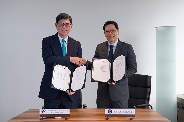 香港金管局总裁陈德霖（左）与泰国中央银行行长Veerathai Santiprabhob签署并交换《谅解备忘录》。