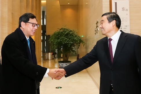 Mr Hu Huaibang, Chairman of CDB (right) greets Mr Norman Chan, Chief Executive of the HKMA (left).