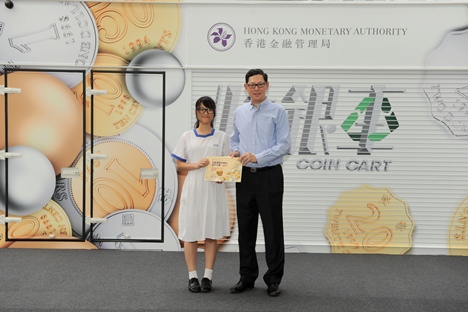 Mr Norman Chan, Chief Executive of the HKMA, presents prizes to the champion of the “Mobile Coin Collection Kiosk Design Competition”.