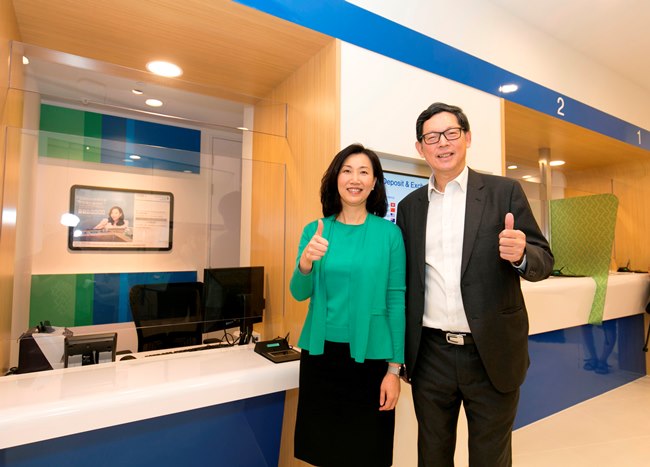 渣打銀行（香港）行政總裁禤惠儀女士（左）向金管局總裁陳德霖先生（右）介紹為便利傷健人士使用高度較低的銀行櫃位。