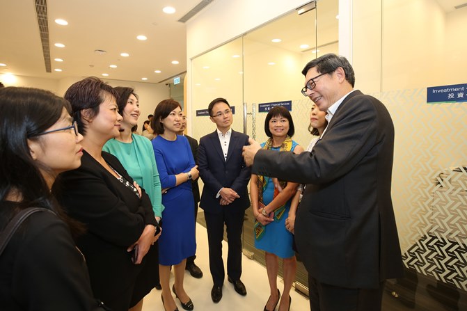 金管局總裁陳德霖先生(右一)與渣打銀行（香港）行政總裁禤惠儀女士（左三）及銀行代表交談，了解分行的營運情況。
