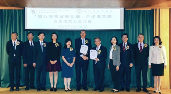 Mr Arthur Yuen, Deputy Chief Executive of the HKMA (fifth from the right), and Mr Simon Vong, Executive Director, Board of Directors of the AMCM (sixth from the left), sign and exchange the Memorandum of Understanding in Macao.