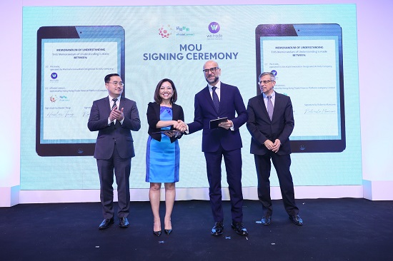 Ms. Haster Tang, Chief Executive Officer of the Hong Kong Trade Finance Platform Company Limited (second from left), and Mr. Roberto Mancone, Chief Operating Officer of we.trade (second from right) sign the Memorandum of Understanding on collaboration. The signing ceremony is witnessed by Mr. Howard Lee, Deputy Chief Executive of the Hong Kong Monetary Authority (first from left) and Mr. Thierry Roehm, Board member of we.trade Innovation Designated Activity Company (first from right).