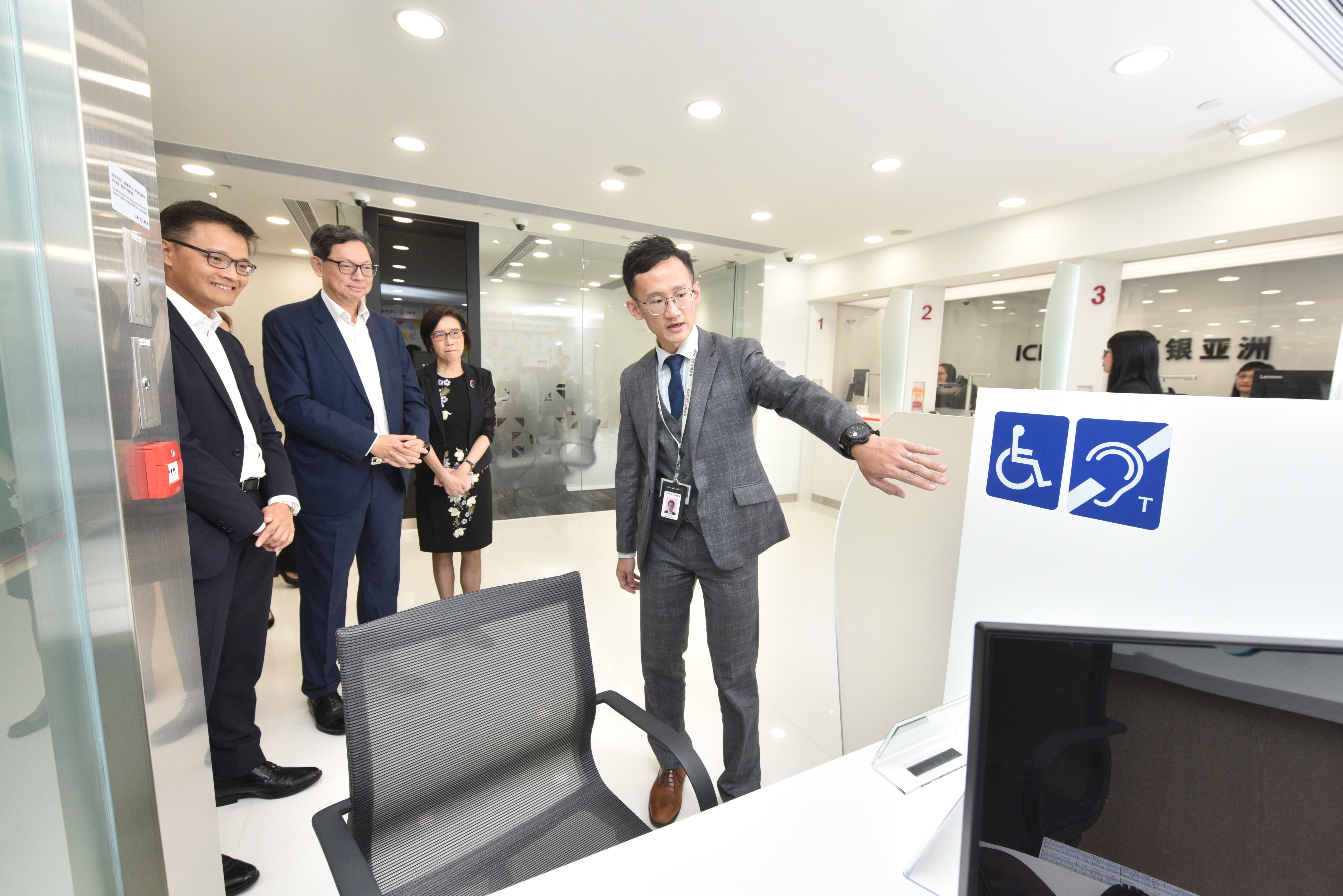 Mr Norman Chan, Chief Executive of the HKMA (second from left) and Ms Gao Ming, Chairman and Executive Director of ICBC (Asia) (second from right), visits the branch in Tsui Lam Estate.