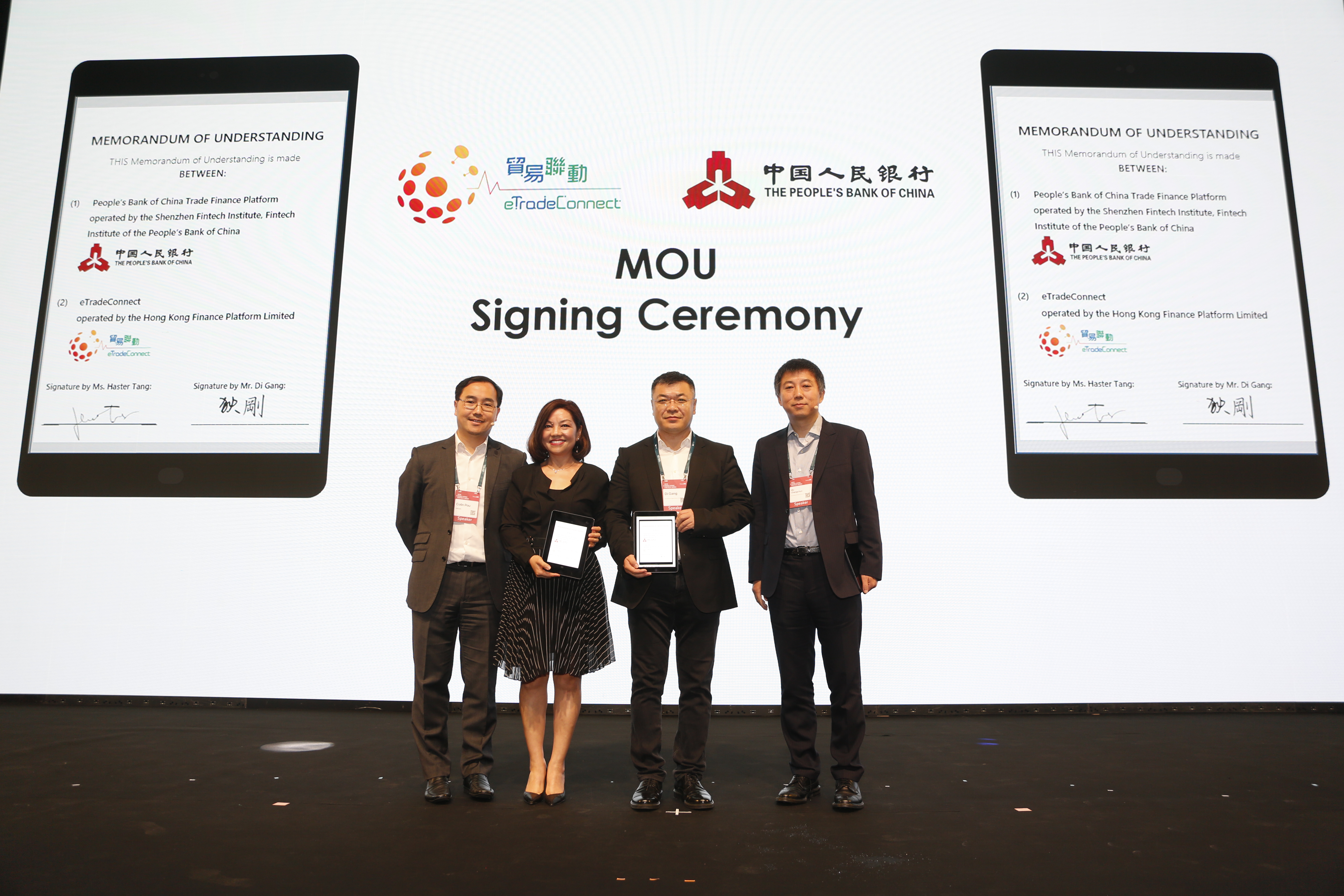 Ms Haster Tang, Chief Executive Officer of the Hong Kong Trade Finance Platform Company Limited (second from left), and Mr Di Gang, Deputy Director-General of the Institute of Digital Currency of the People’s Bank of China and Director of Shenzhen Fintech Institute (second from right), sign the Memorandum of Understanding to conduct a Proof-of-Concept trial. The signing ceremony is witnessed by Mr Colin Pou, Executive Director (Financial Infrastructure) of the HKMA (first from left), and Mr Mu Changchun, Director-General of the Institute of Digital Currency of the People’s Bank of China (first from right).