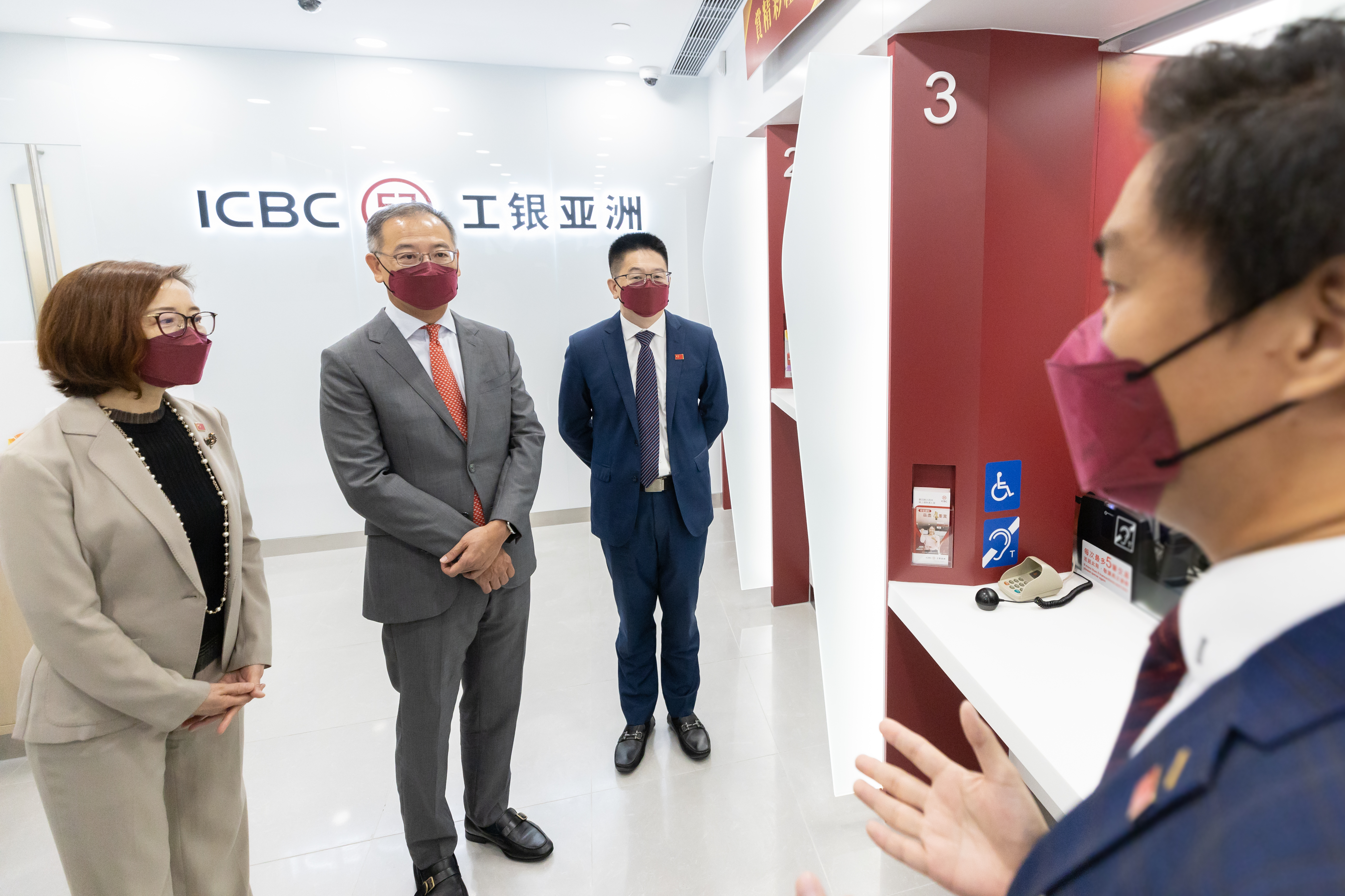 Mr. Eddie Yue, Chief Executive of the HKMA (second from left), Mr. Sun Xiangyi, the Director-General of the Economic Affairs Department of the Liaison Office of the Central People's Government in the Hong Kong Special Administrative Region (third from left) and Ms. Gao Ming, Chairman and Executive Director of ICBC (Asia) (first from left), visit the branch at Queens Hill Estate.