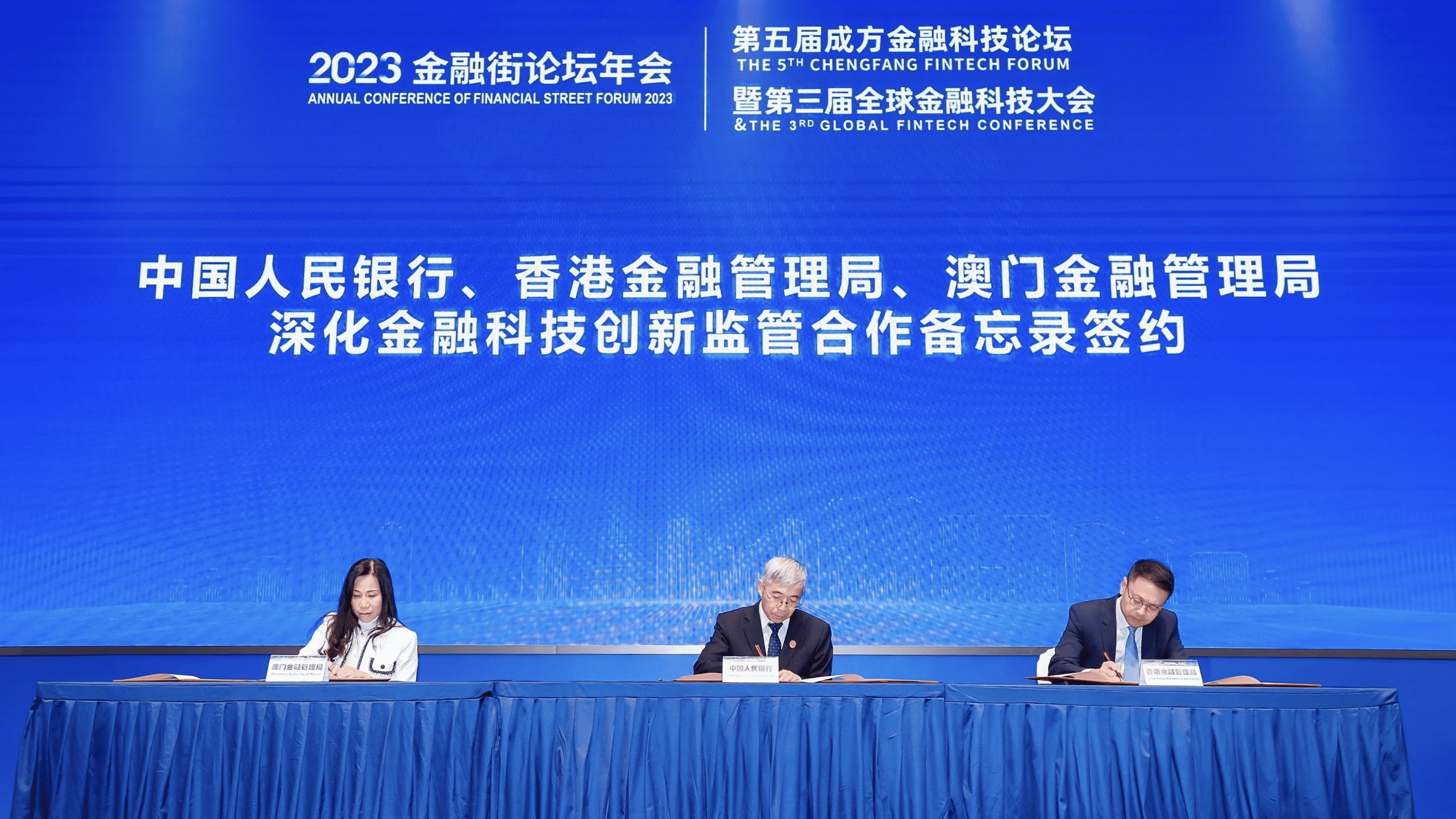 Mr Zhang Qingsong, Deputy Governor of the People's Bank of China (centre);  Mr Raymond Chan, Executive Director (Banking Supervision) of the Hong Kong Monetary Authority (right); and Ms Lau Hang-kun, Henrietta, Executive Director of the Monetary Authority of Macao (left), sign the 