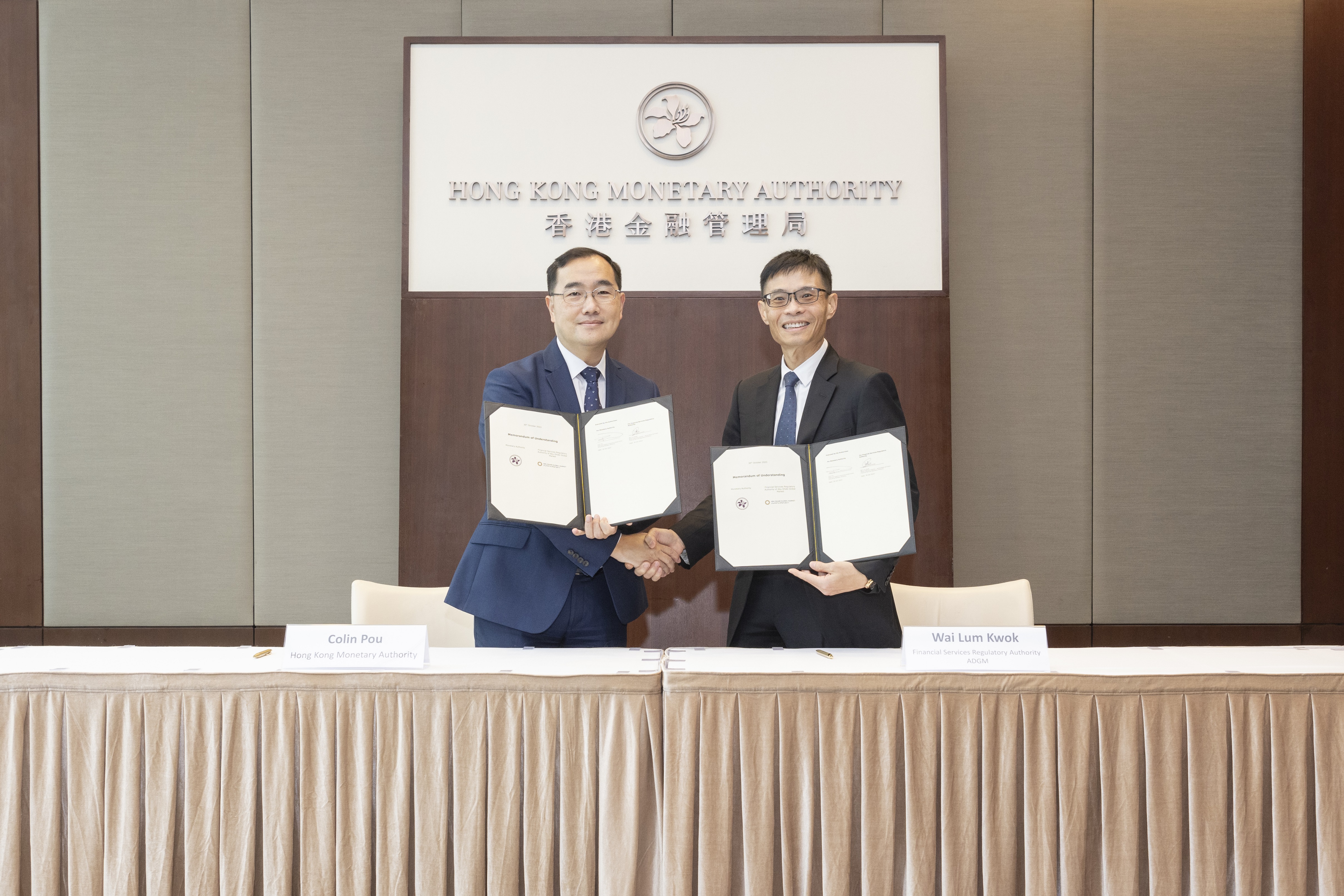 Mr Colin Pou, Executive Director (Financial Infrastructure) of the Hong Kong Monetary Authority (left), and Mr Wai Lum Kwok, Senior Executive Director - Authorisation & Fintech of the Financial Services Regulatory Authority (right), sign and exchange the Memorandum of Understanding in Hong Kong.