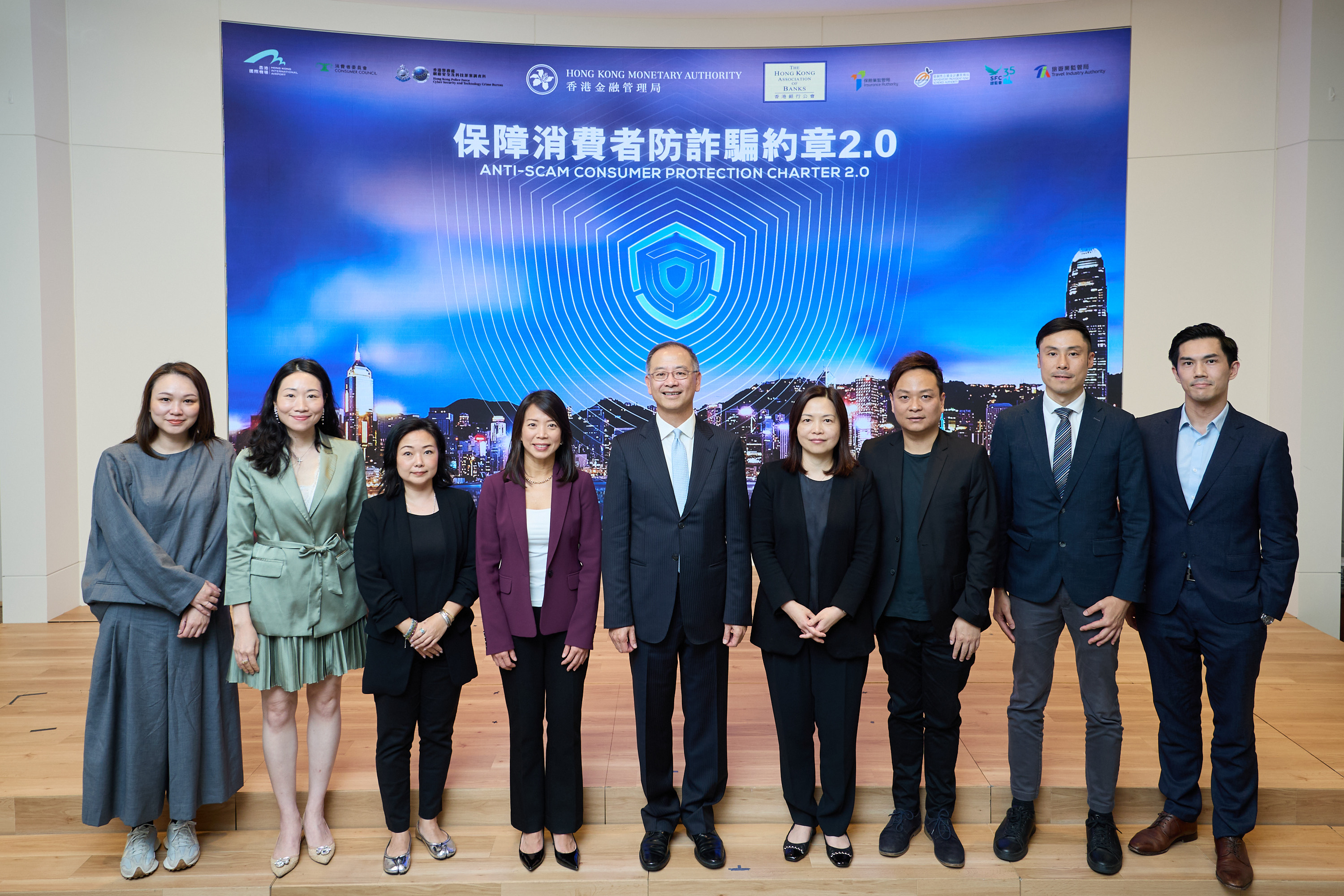 Mr Eddie Yue, Chief Executive of the Hong Kong Monetary Authority (fifth from left); Ms Luanne Lim, Chairman of the Hong Kong Association of Banks and Chief Executive Officer, Hong Kong, HSBC (fourth from left); and representatives of merchant institutions attend the event to support the Anti-Scam Consumer Protection Charter 2.0.