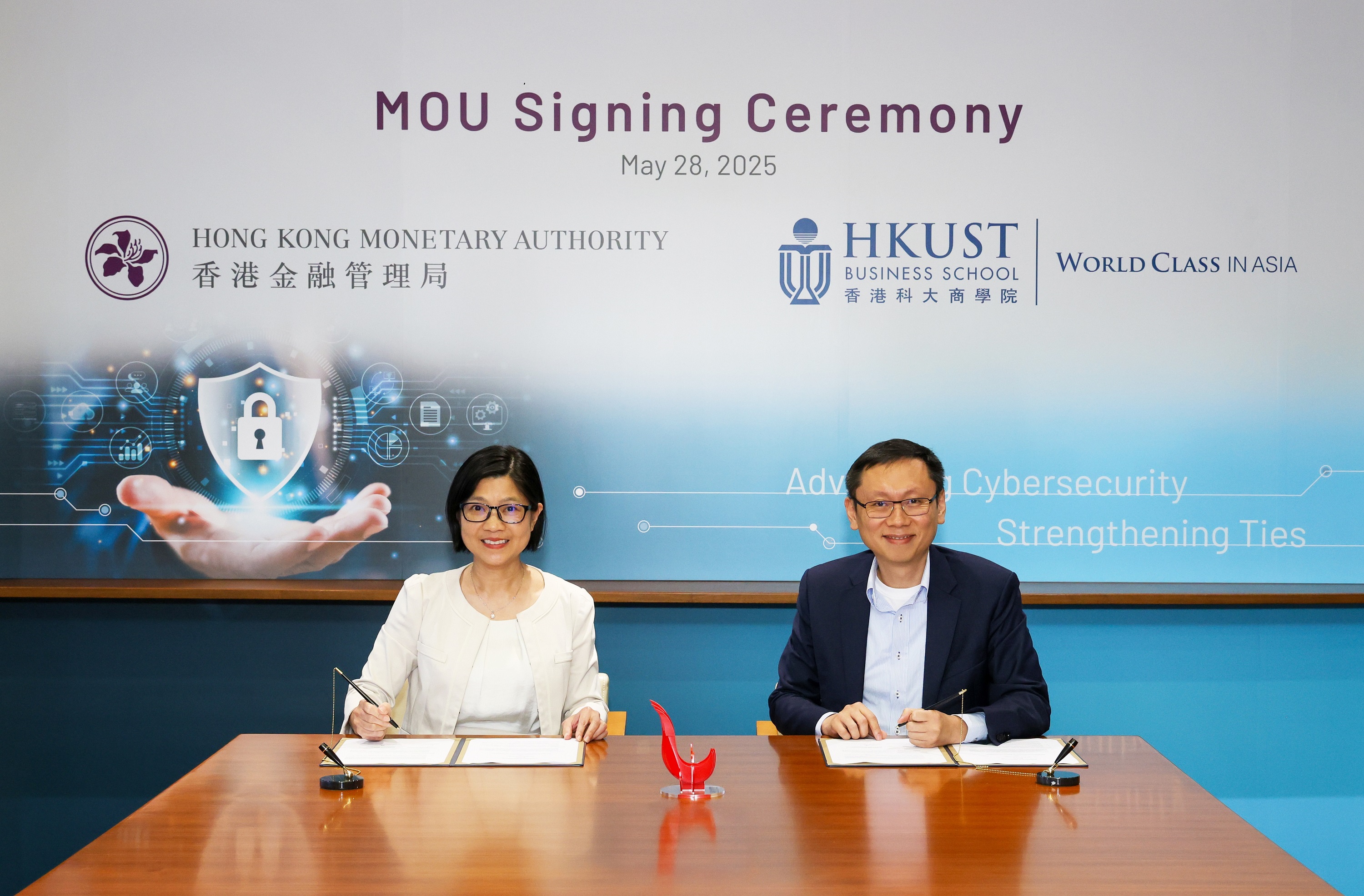 Ms Carmen Chu (left), Executive Director (Banking Supervision) of the Hong Kong Monetary Authority, and Professor Hui Kai-Lung (right), Acting Dean of the School of Business and Management of the Hong Kong University of Science and Technology, sign a Memorandum of Understanding to advance cybersecurity research for the financial sector.
