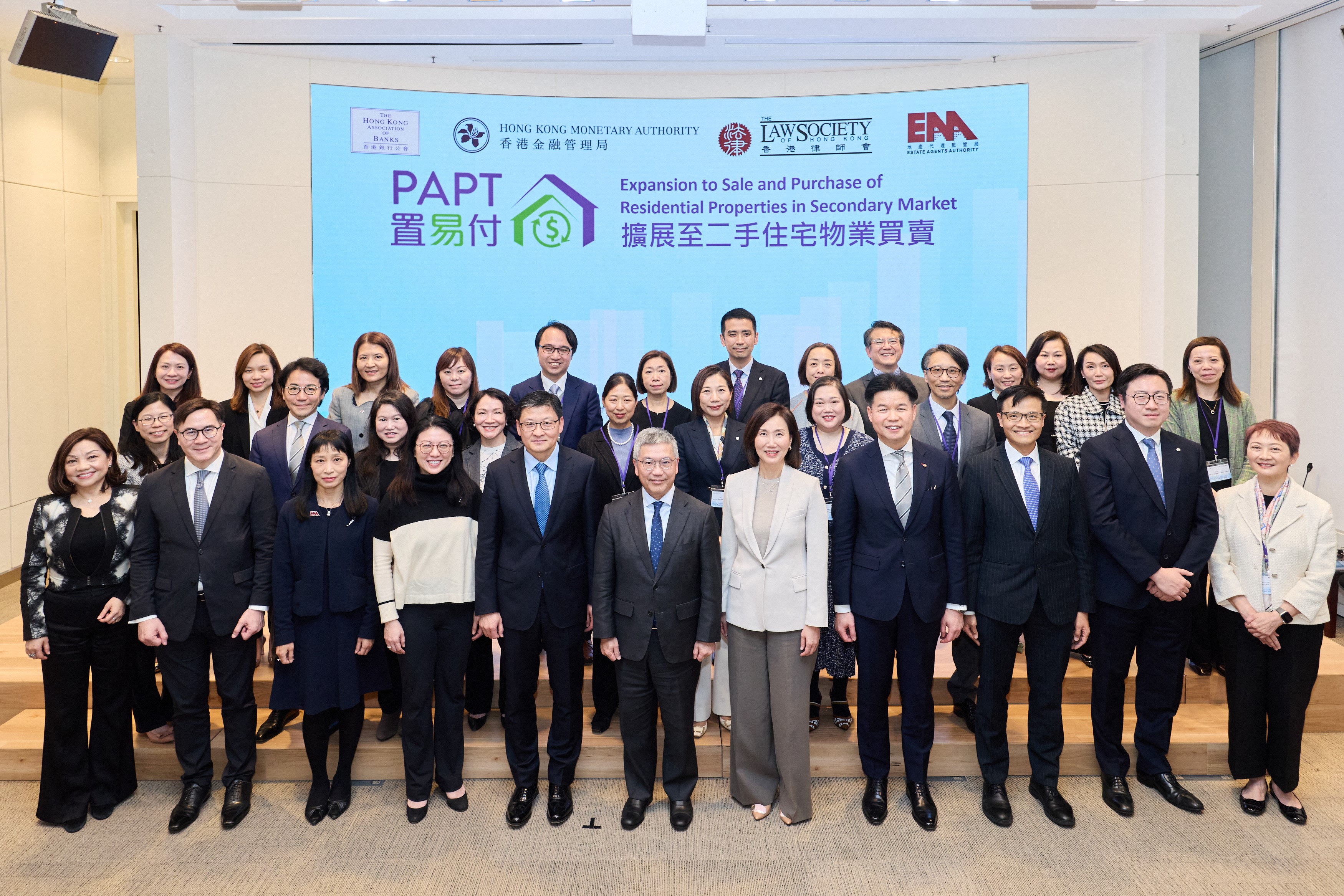 Mr Arthur Yuen (centre, front row), Deputy Chief Executive of the Hong Kong Monetary Authority (HKMA); Mr Sun Yu (fifth from left, front row), Chairman of The Hong Kong Association of Banks, and Vice Chairman and Chief Executive of Bank of China (Hong Kong) Limited; Mr Roden Tong (fourth from right, front row), President of The Law Society of Hong Kong; Ms Juliet Leung (third from left, front row), Director of Regulatory Affairs and General Counsel of the Estate Agents Authority; Ms Maggie Ng (fourth from left, front row), Chief Executive Officer of The Hongkong and Shanghai Banking Corporation Limited; Ms Mary Huen (fifth from right, front row), CEO, Hong Kong and Greater China & North Asia of Standard Chartered; Mr Francis Ho (second from left, front row), Deputy Chief Executive of the Consumer Council; Mr Alan Au (third from right, front row), Executive Director (Banking Conduct) of the HKMA; Ms Haster Tang (first from left, front row), Chief Executive Officer of the Hong Kong Interbank Clearing Limited; and the bank representatives who joined the pilot run, attend the announcement of PAPT’s expansion.