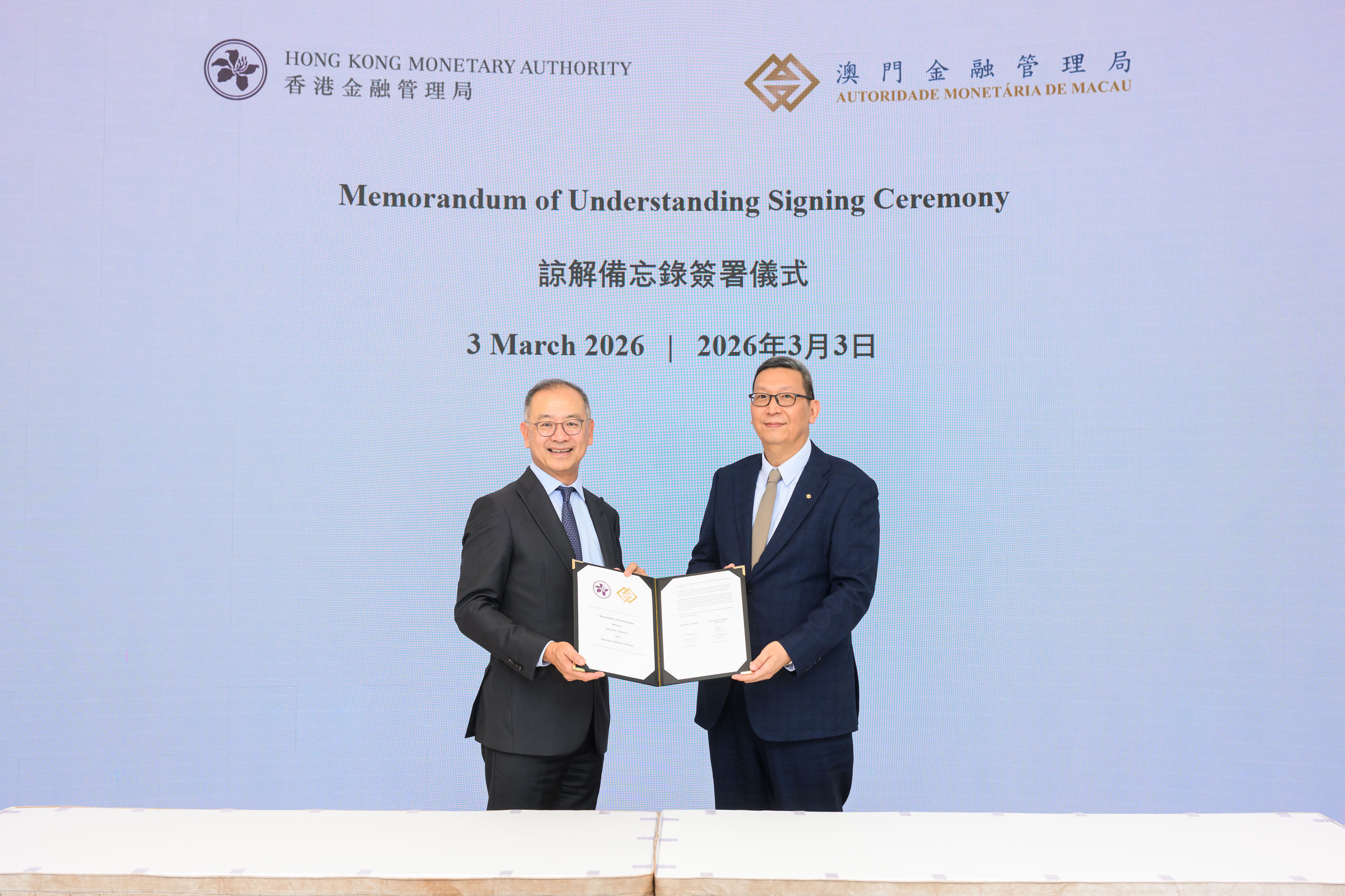 Mr Eddie Yue (left), the Chief Executive of the Hong Kong Monetary Authority, and Mr Simon Vong (right), the Chairman of the Monetary Authority of Macao, sign a revised Memorandum of Understanding.
