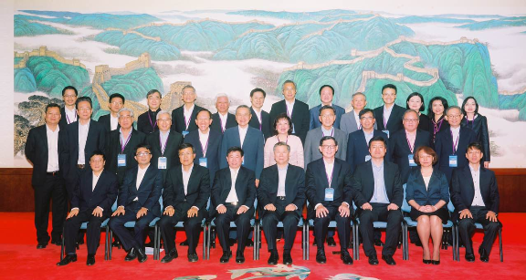 图一：中国银监会主席尚福林出席座谈会与与会者交流并合影留念。